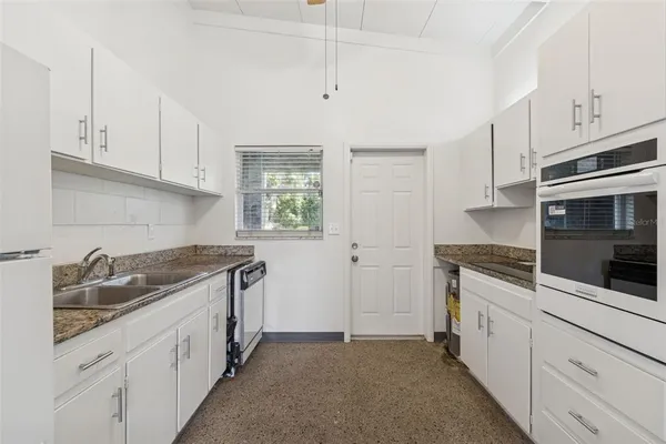 a kitchen with granite countertop a sink stove and cabinets