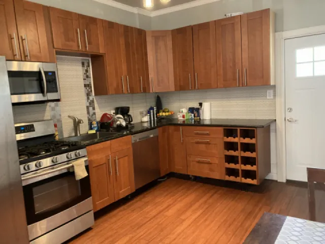 a kitchen with granite countertop wooden cabinets and stainless steel appliances