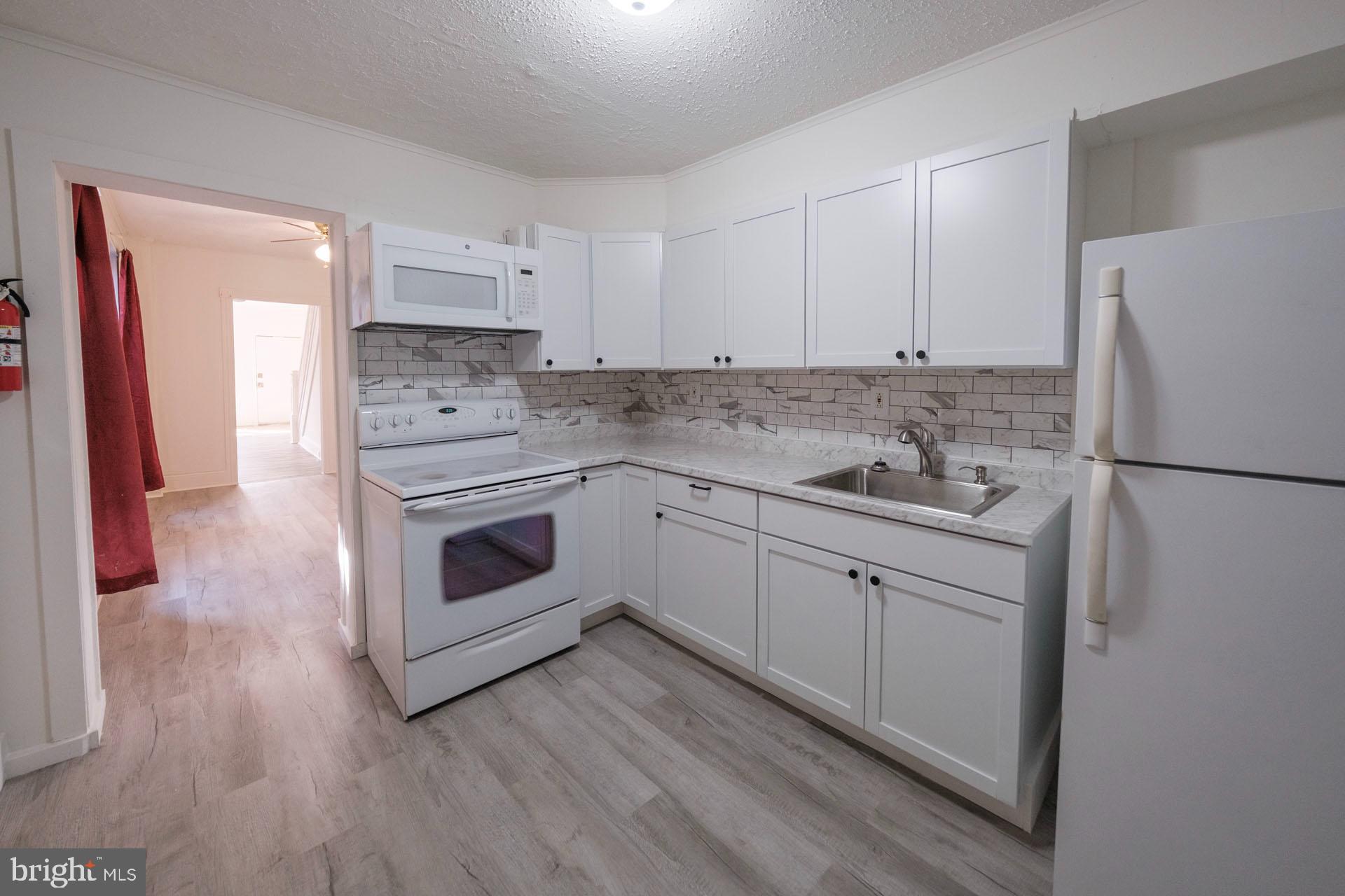 525 South 18th Street Reading, PA 19606 - Photo 6 of 18 a kitchen with a white cabinets and white appliances
