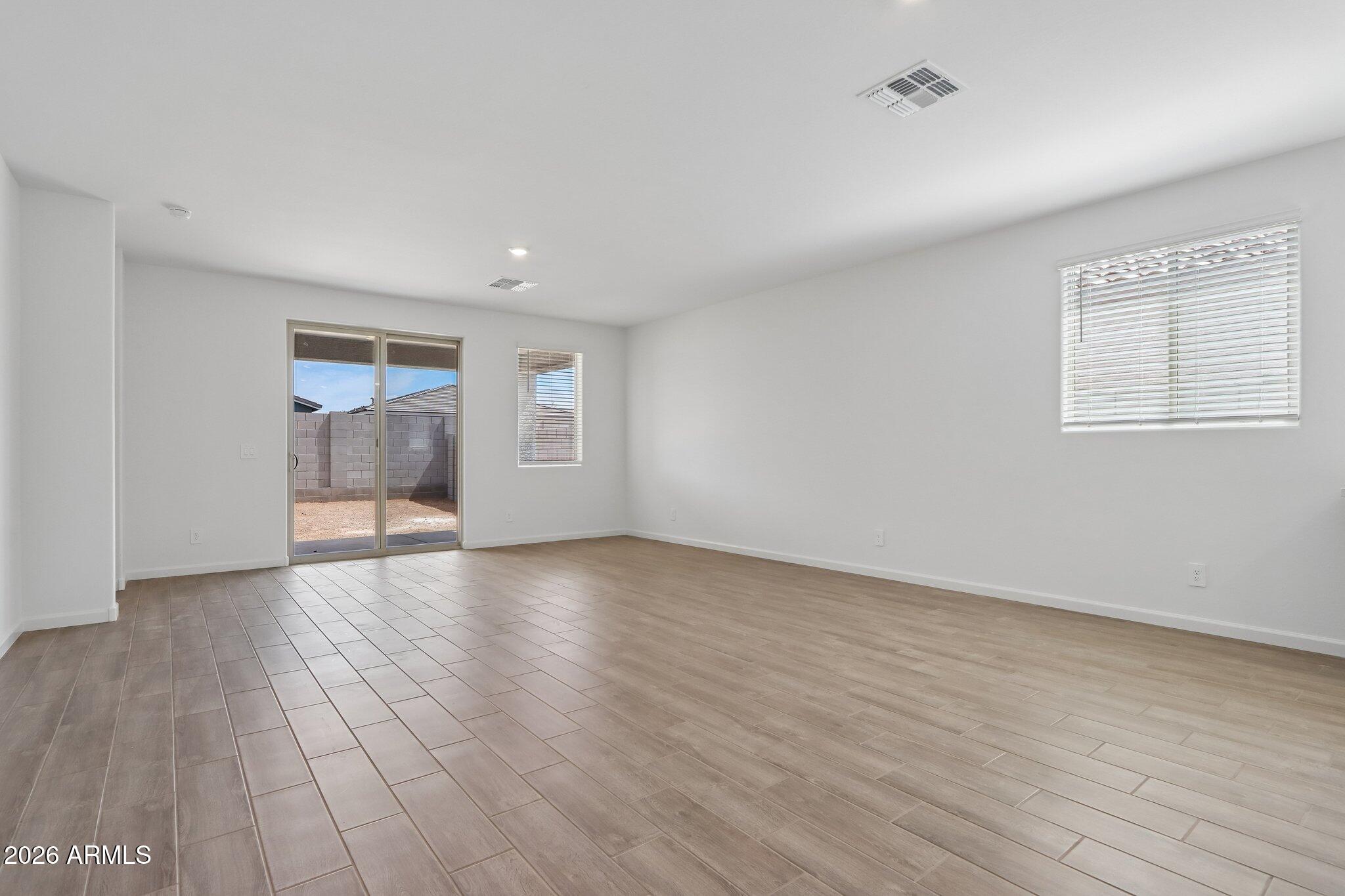 9544 West Gaby Road Tolleson, AZ 85353 - Photo 4 of 43 a view of an empty room with wooden floor and a window