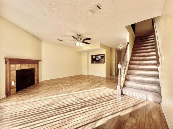 a view of a livingroom with wooden floor and a ceiling fan