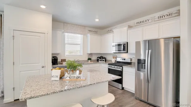 a kitchen with stainless steel appliances granite countertop a refrigerator a stove a sink and a granite counter tops