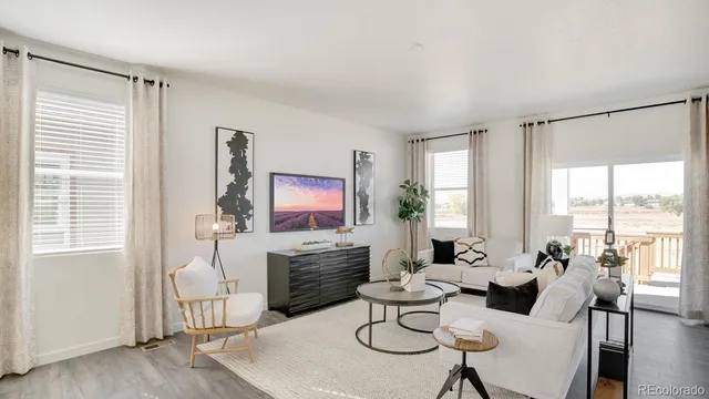 a living room with furniture a large window and a flat screen tv