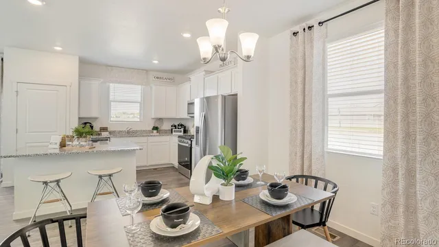 a kitchen with stainless steel appliances a dining table and chairs