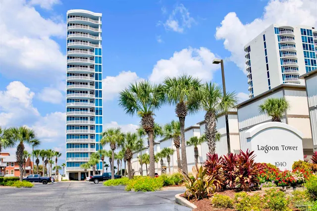 a front view of a multi story residential apartment building with yard and sign board