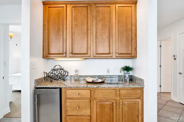 a kitchen with stainless steel appliances granite countertop a sink a refrigerator and a stove with wooden floor