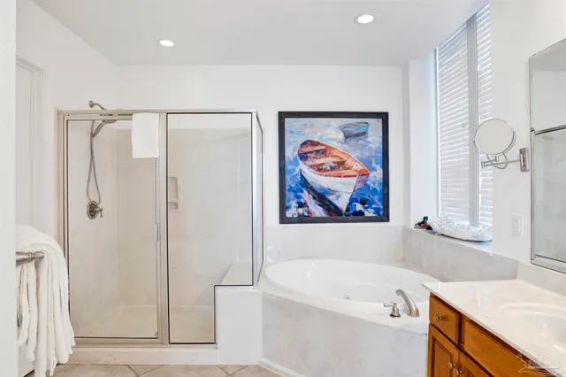 a white bath tub sitting next to a white sink and cabinets
