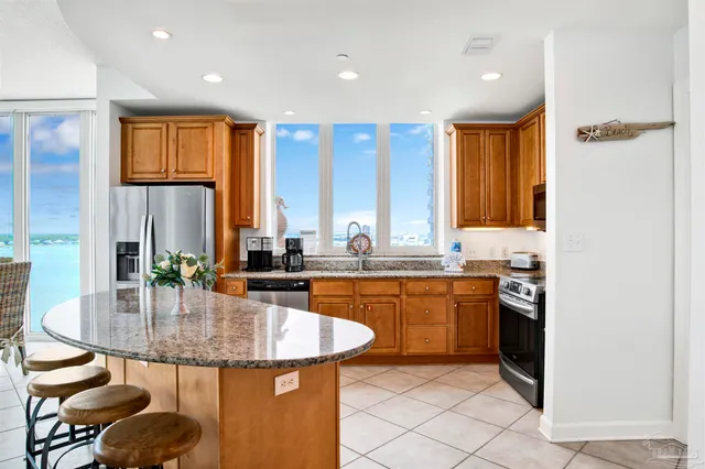 a kitchen with granite countertop kitchen island stainless steel appliances a table and chairs in it