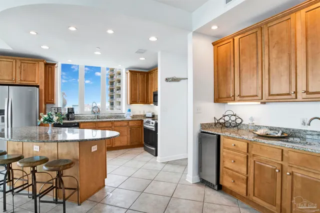 a kitchen with stainless steel appliances granite countertop a stove a sink and a refrigerator
