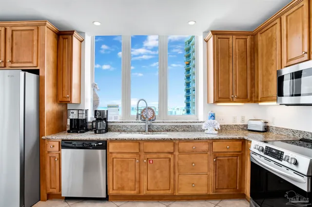 a kitchen with stainless steel appliances granite countertop a stove a sink and a microwave