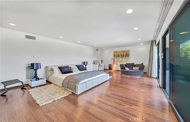 a spacious bedroom with a large bed and a large window