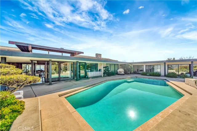 a view of a house with swimming pool and sitting area