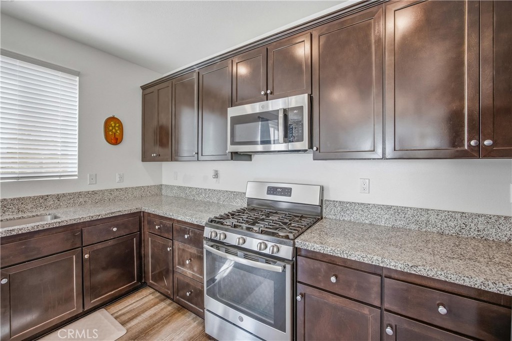 925 Bluebell Way Beaumont, CA 92223 - Photo 14 of 33 a kitchen with granite countertop cabinets stainless steel appliances and a sink