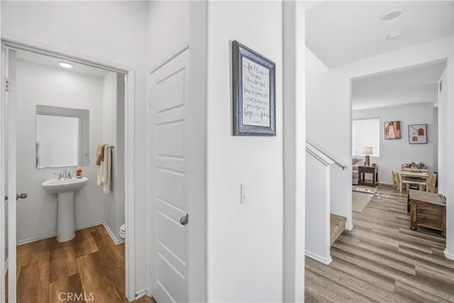 a view of a hallway with wooden floor and closet