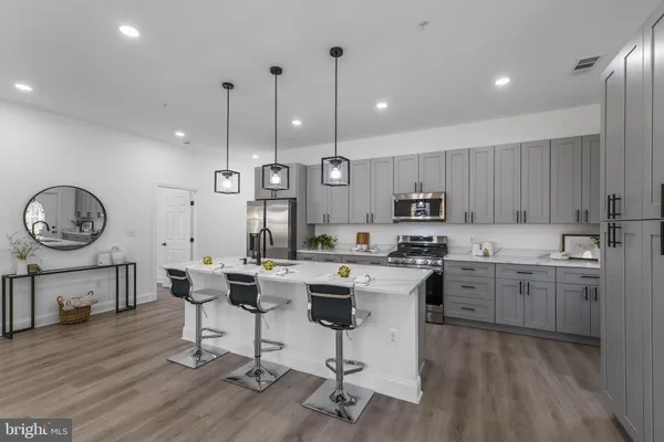 a kitchen with granite countertop a stove a sink a stove a dining table and chairs