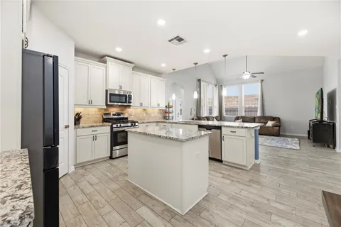a kitchen with a refrigerator sink and cabinets