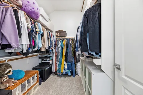 a view of walk in closet with clothes and shoes