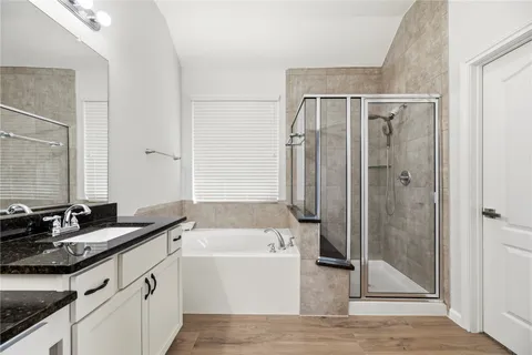 a bathroom with a granite countertop sink mirror and a bathtub