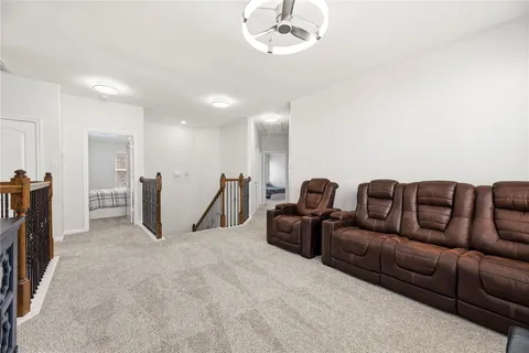 a living room with furniture a ceiling fan and a rug