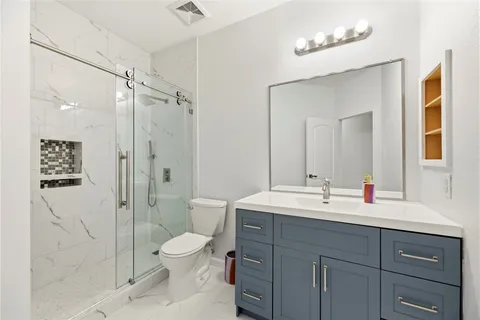 a bathroom with a toilet sink a shower and a mirror