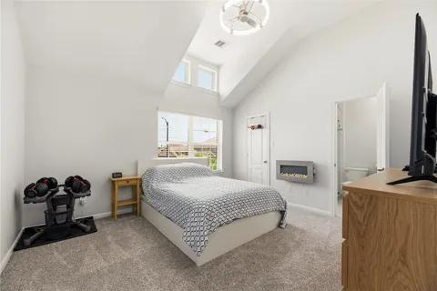 a bedroom with a bed and a flat tv screen on dresser