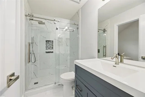 a bathroom with a sink a toilet and shower