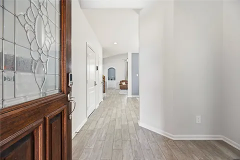 a view of a hallway with wooden floor and staircase