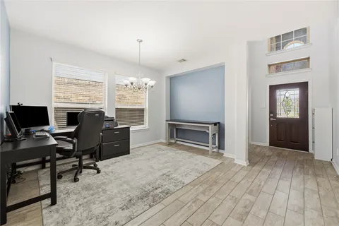 a view of a workspace with furniture and a window