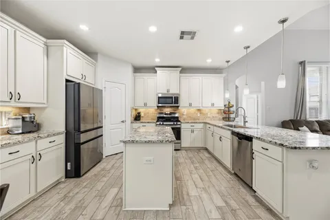 a kitchen with a refrigerator a sink and cabinets