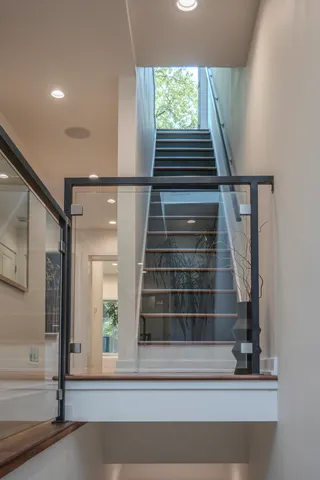 a view of a hallway with wooden floor and staircase