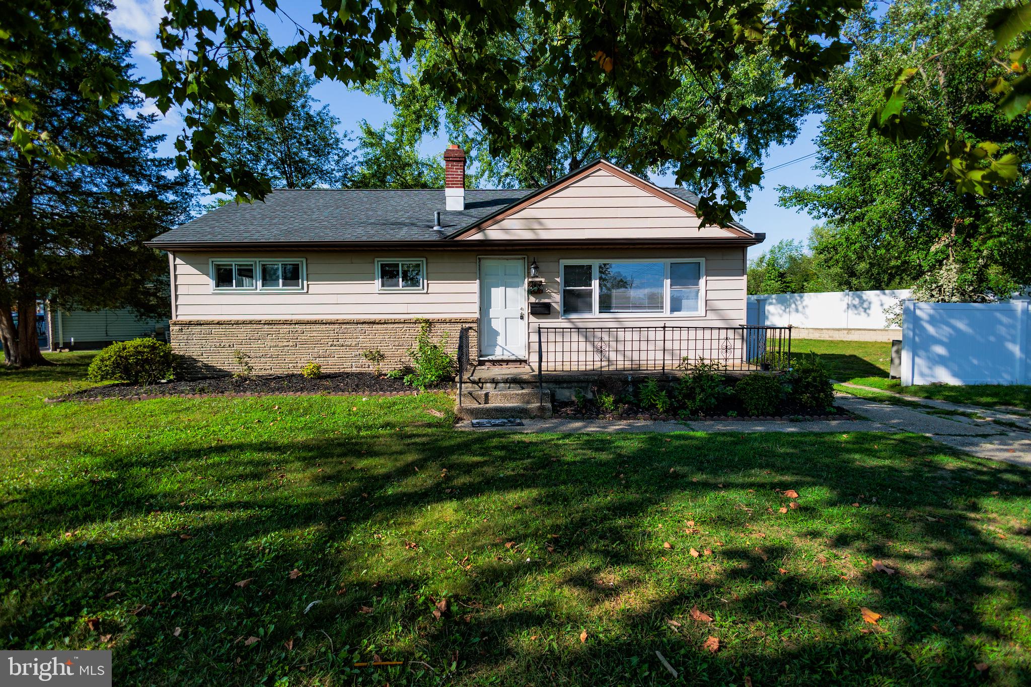 a front view of a house with a yard and green space