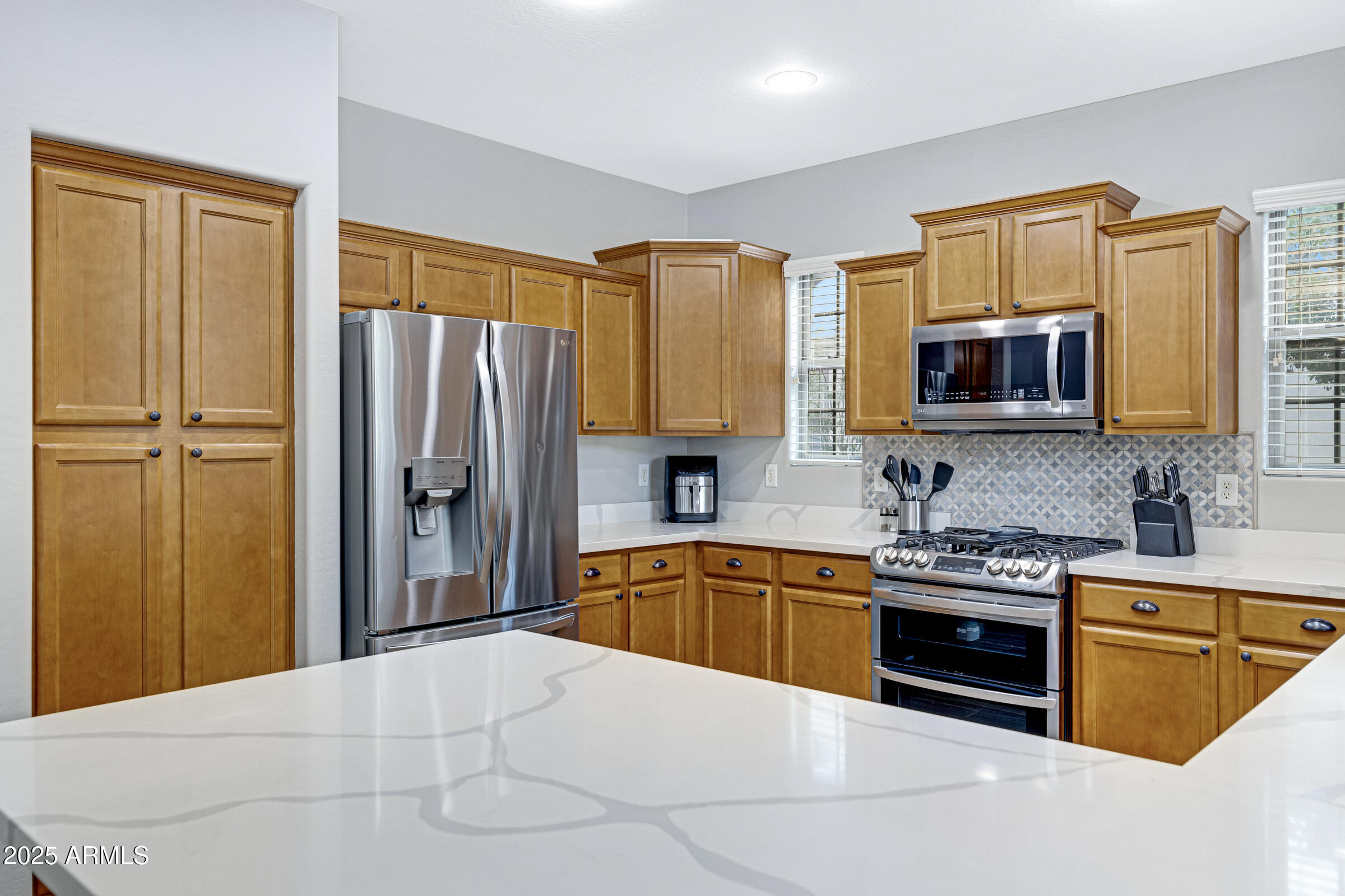 15366 West Bloomfield Road Surprise, AZ 85379 - Photo 12 of 48 a kitchen with stainless steel appliances granite countertop a stove a sink dishwasher a refrigerator and a microwave oven