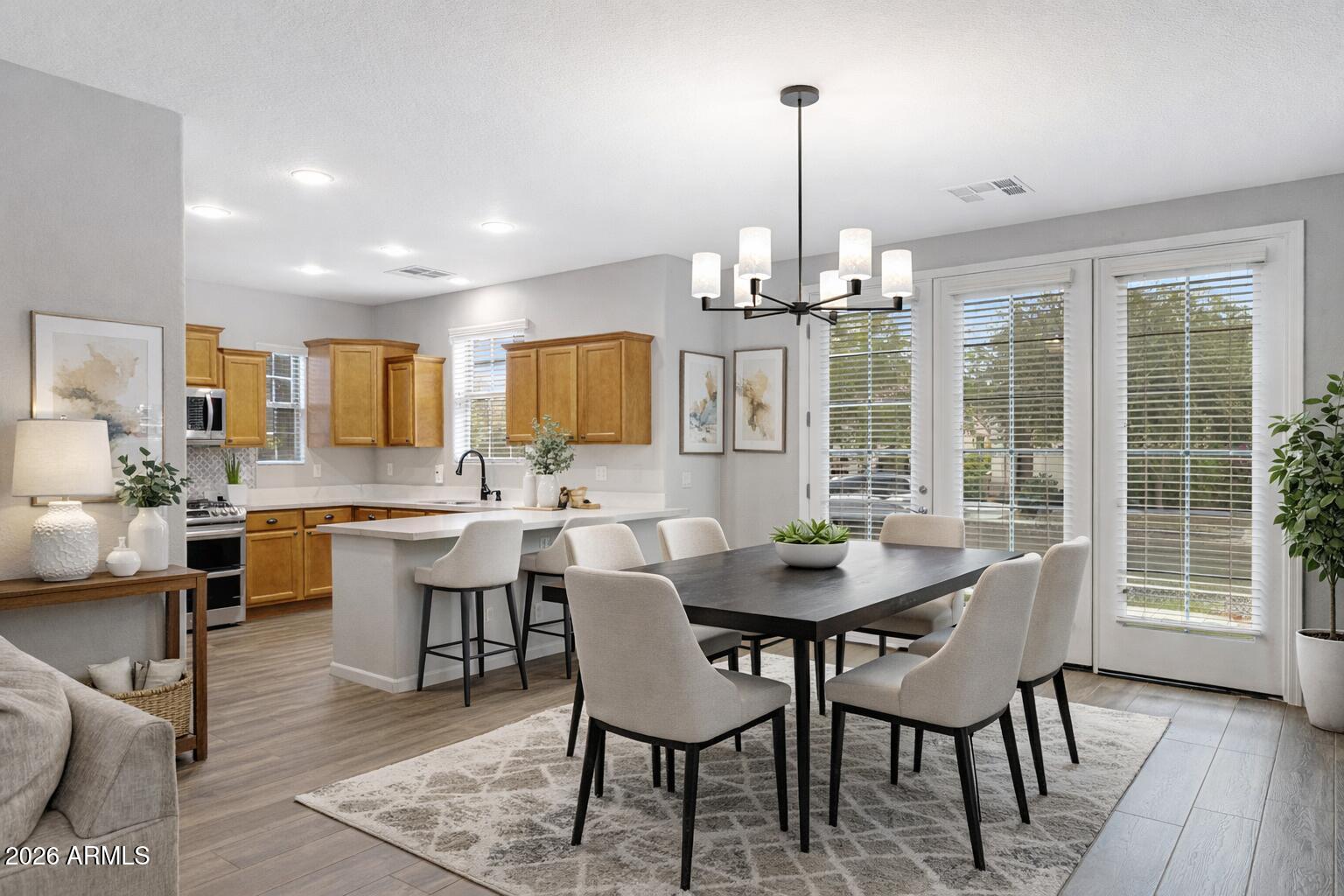 15366 West Bloomfield Road Surprise, AZ 85379 - Photo 9 of 48 a dining room with furniture a chandelier and wooden floor