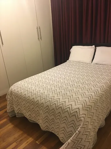 a bed sitting in a bedroom next to a wooden cabinet