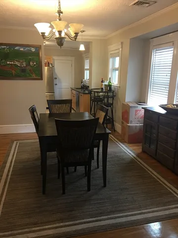 a view of a a dining room with furniture window and wooden floor