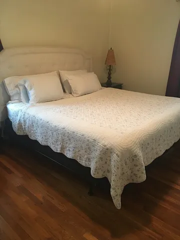 a bed sitting in a bedroom next to a window