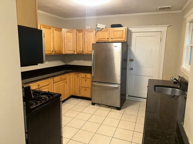 a kitchen with a refrigerator and a stove top oven