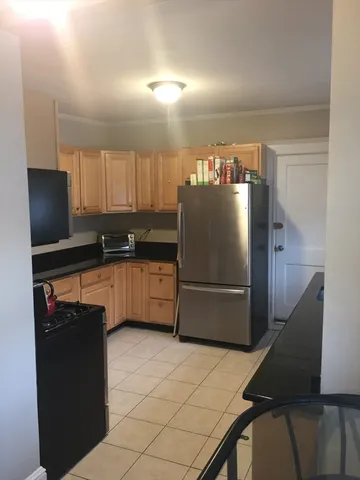 a kitchen with granite countertop a refrigerator and a sink