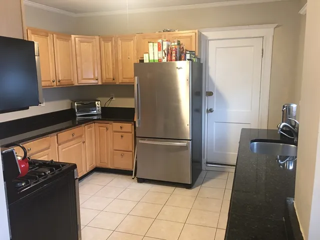 a kitchen with granite countertop a refrigerator and a sink