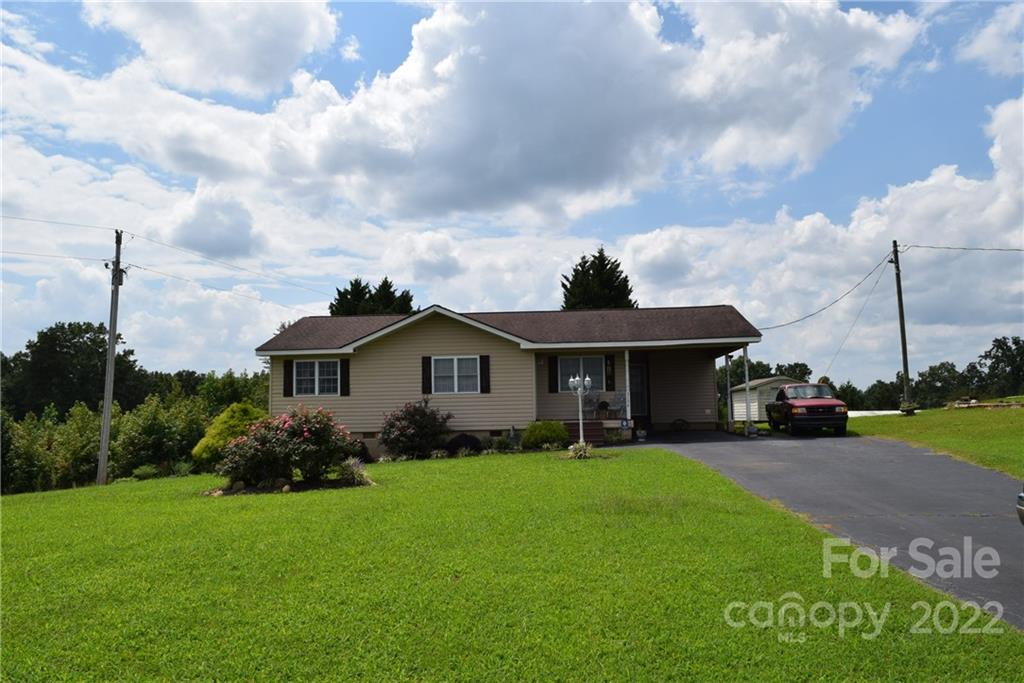 3136 Pea Ridge Road Mill Spring, NC 28756 - Photo 1 of 24 a front view of a house with garden
