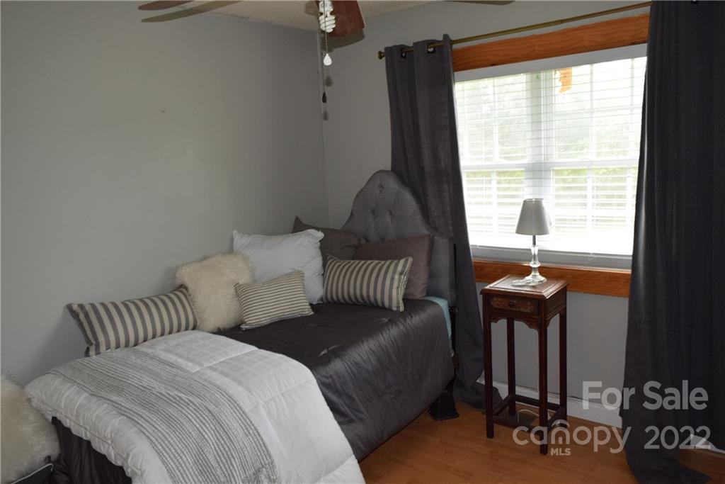 3136 Pea Ridge Road Mill Spring, NC 28756 - Photo 15 of 24 a bedroom with furniture and a window