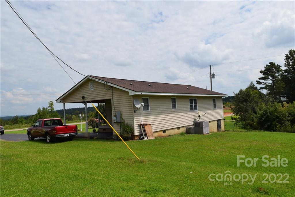 3136 Pea Ridge Road Mill Spring, NC 28756 - Photo 21 of 24 a front view of a house with a garden