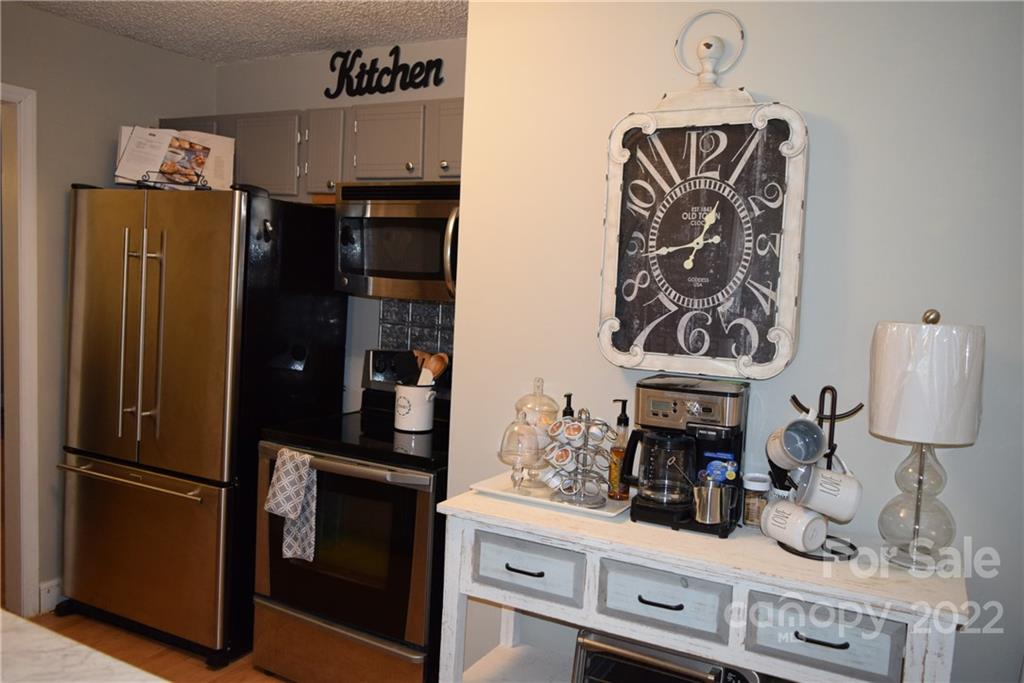 3136 Pea Ridge Road Mill Spring, NC 28756 - Photo 10 of 24 a kitchen with a refrigerator and cabinets