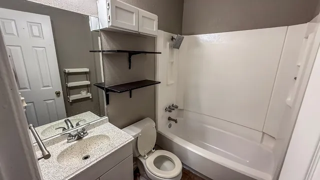a bathroom with a toilet sink and mirror