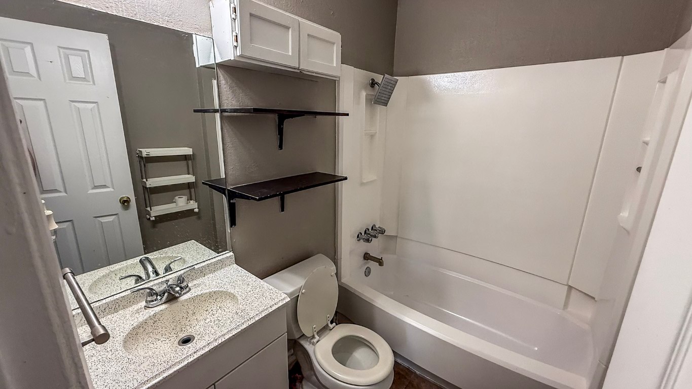501 Hardin Court, Unit D Austin, TX 78753 - Photo 11 of 13 a bathroom with a granite countertop sink toilet and a bathtub