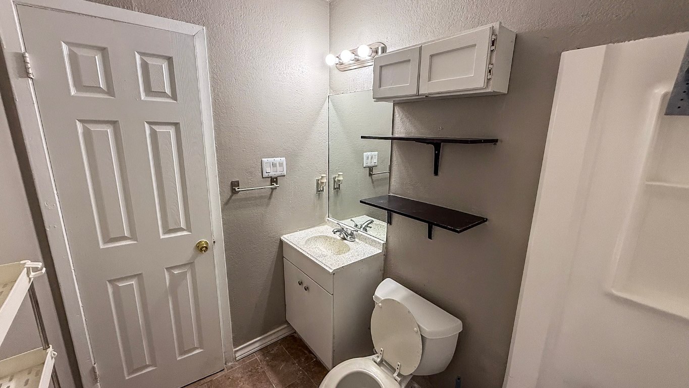 501 Hardin Court, Unit D Austin, TX 78753 - Photo 12 of 13 a bathroom with a toilet sink and mirror