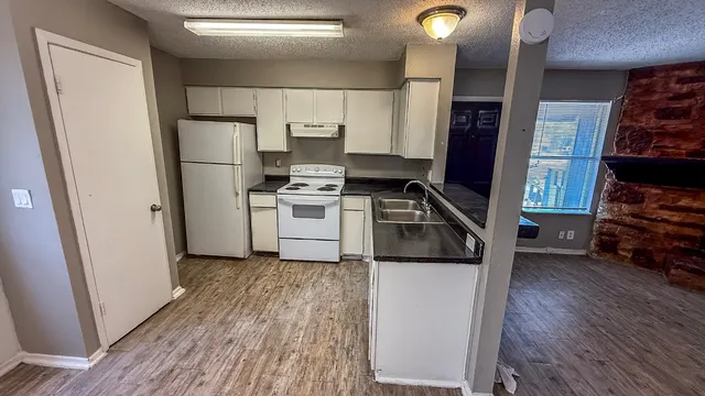 a kitchen with a refrigerator and a stove top oven