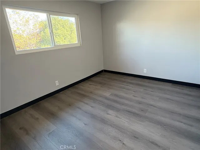 a hallway with entryway door wooden floor and cabinet