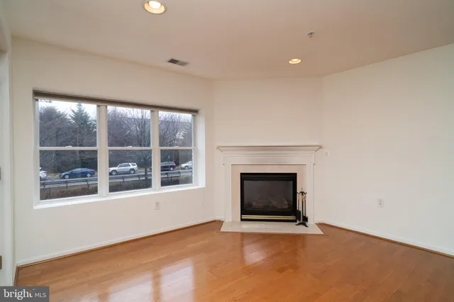 a view of an empty room with a window and fireplace
