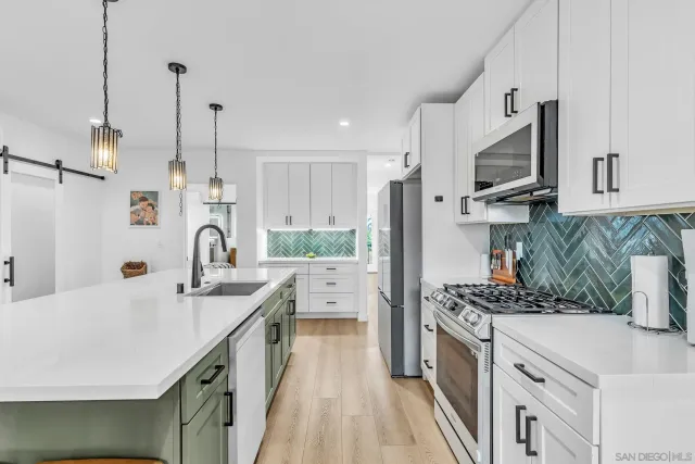 a kitchen with a sink a stove and a wooden floor
